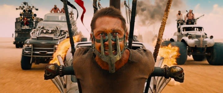 Tom Hardy as Max Rockatansky strapped to the front of a speeding car in Mad Max: Fury Road