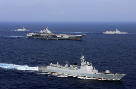 FILE PHOTO: China's aircraft carrier Liaoning (C) takes part in a military drill of Chinese People's Liberation Army (PLA) Navy in the western Pacific Ocean, April 18, 2018. REUTERS/Stringer/File Photo