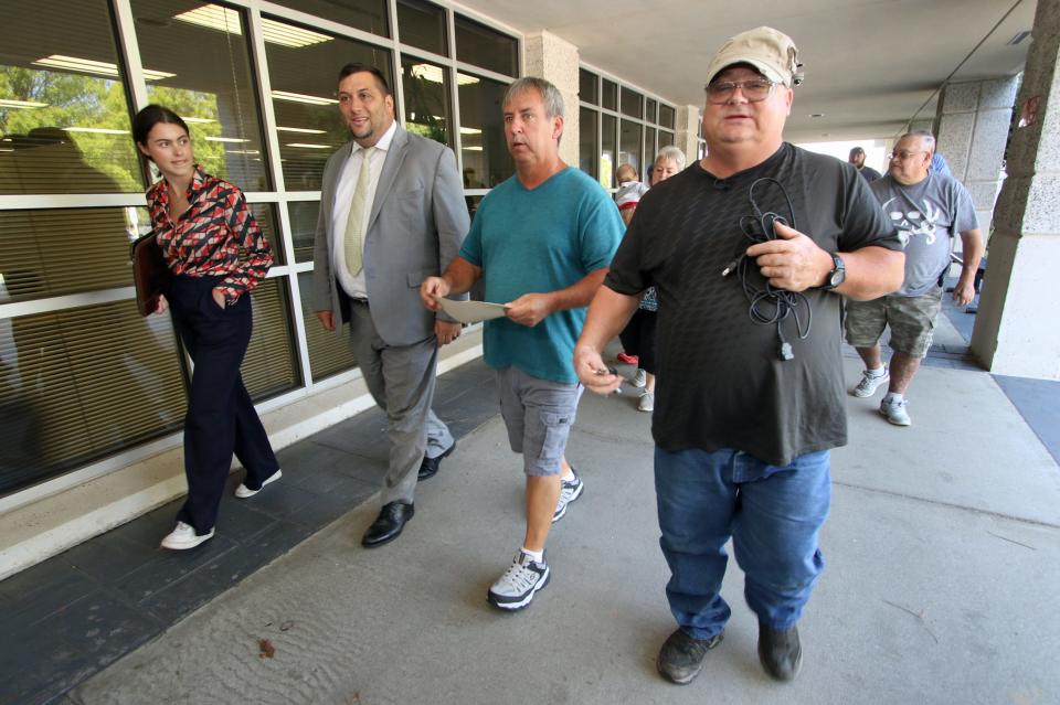 Mark Carver, right, along with his attorney and family walk to the main entrance of the Gaston County Courthouse to have his ankle monitor removed Friday afternoon, August 12, 2022.