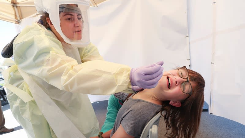 Ruby Van Wagenen, 11, is held by her mother as she is tested for COVID-19 by medical assistant Nicole Paepke at Utah Valley Hospital in Provo on Friday, May 8, 2020. In an effort to help address COVID-19 hot spots that have been identified in Utah County, the Intermountain Healthcare Coronavirus Mobile Testing Unit  provided testing to area residents.