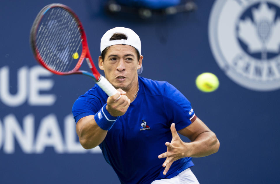 Sebastián Báez, of Argentina, returns to Nick Kyrgios, of Australia, during the National Bank Open tennis tournament Tuesday, Aug. 9, 2022, in Montreal. (Paul Chiasson/The Canadian Press via AP)