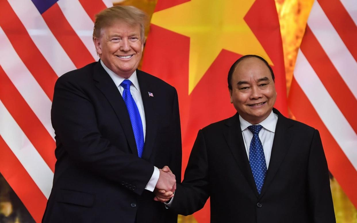 Donald Trump, left, shakes hands with Vietnam's Prime Minister Nguyen Xuan Phuc - AFP