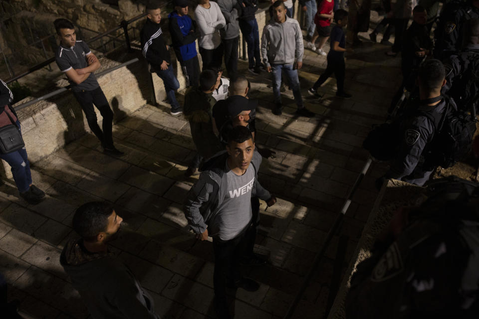 A Palestinian youth speaks with Israeli police who gathered in force at Damascus Gate to the Old City of Jerusalem as worshippers took part in the evening prayer during the Muslim holy month of Ramadan, Saturday, April 24, 2021. Clashes between police and Palestinian protesters here have become a nightly occurrence throughout the Muslim holy month of Ramadan. (AP Photo/Maya Alleruzzo)