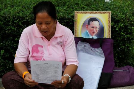 A well-wisher wears a pink shirt as she prays in front of a portrait of Thailand's King Bhumibol Adulyadej at Siriraj Hospital in Bangkok, Thailand, October 11, 2016. REUTERS/Chaiwat Subprasom