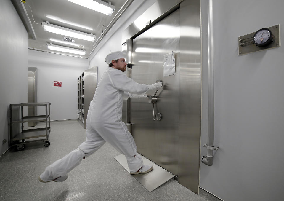 Jeremy Kent, Apollo sample curation processor, tugs to open the 1978 U.S. federal bank vault that protects the entrance to the lunar sample vault inside the lunar lab at the NASA Johnson Space Center Monday, June 17, 2019, in Houston. The door requires two separate combinations, held by two separate people, to open. (AP Photo/Michael Wyke)
