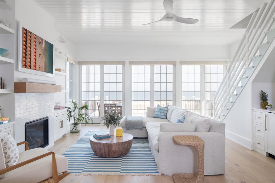 a white living room with a fireplace and white sofa