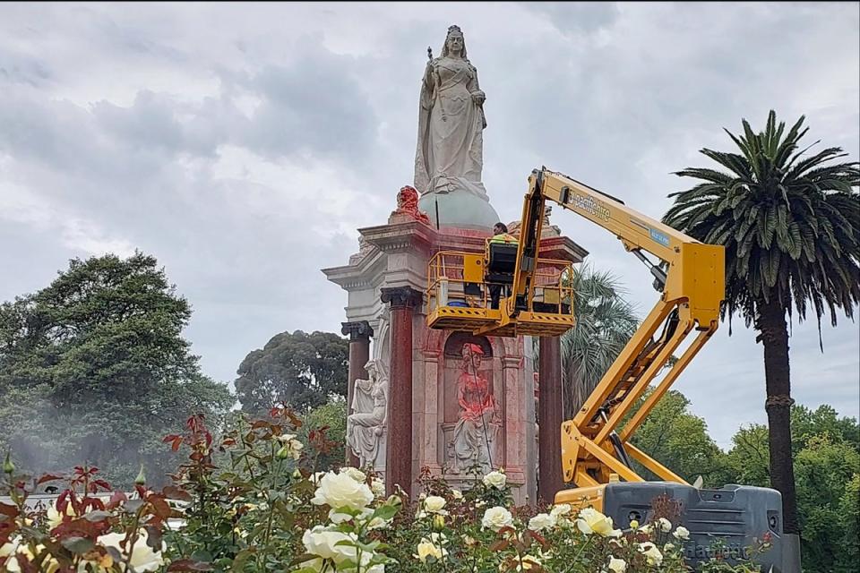 A worker cleans the statue of Queen Victoria that was defaced (AFP/Getty)