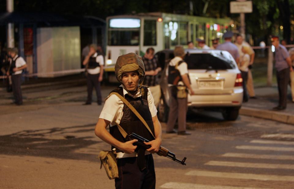 FILE - In this Tuesday, Aug. 17, 2010 file photo police officers guard the site of an explosion after a parked car exploded outside a cafe in downtown Pyatigorsk, a city in southern Russia. A series of unexplained killings in southern Russia involving booby-trapped bombs has further heightened security fears ahead of next month's Winter Olympics in Sochi. A spokesman for Russia's main investigative agency, said in a statement that no motive had yet been found for the killings on Wednesday, Jan. 8, 2014 on the outskirts of Pyatigorsk, which is the center of an administrative district created in 2010 to coordinate efforts to combat the insurgency. (AP Photo/Viktor Korotayev, File)