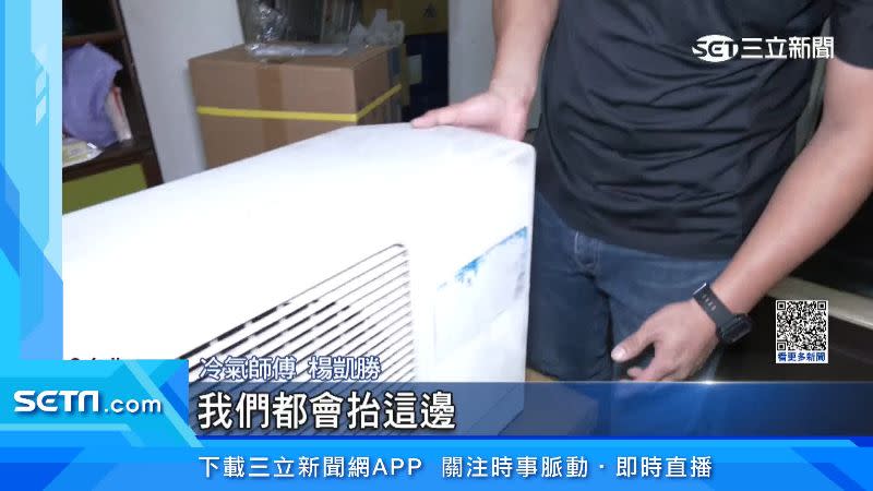 冷氣師傅示範如何抬取冷氣室外機。