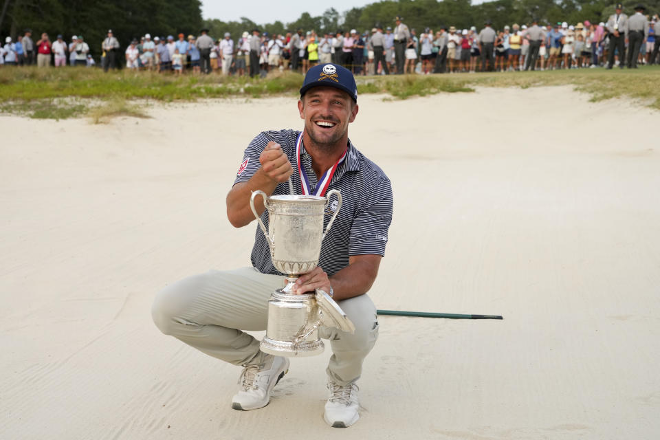 Bryson DeChambeau holds the trophy in the bunker after winning the U.S. Open golf tournament Sunday, June 16, 2024, in Pinehurst, N.C. (AP Photo/Matt York)