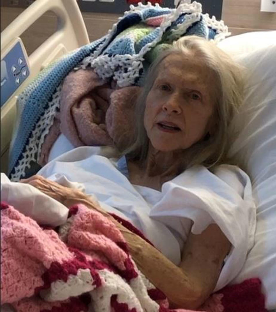 An elderly woman is pictured lying in a hospital bed. A search for her family is underway after she was picked up by a driver on the side of a Queensland road two weeks ago.