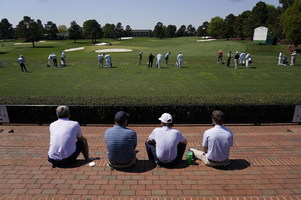 Patrons watch players warm up on the range before a practice round for the Masters golf tournament on Tuesday, April 6, 2021, in Augusta, Ga. (AP Photo/Charlie Riedel)