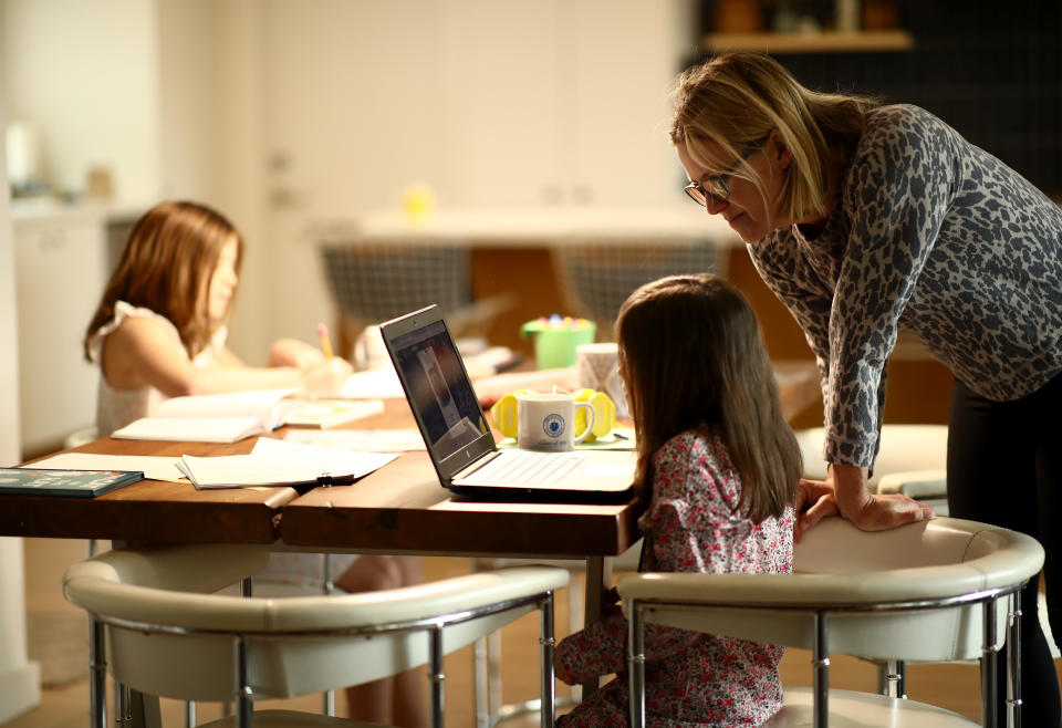 SAN ANSELMO, CALIFORNIA - MARCH 18:  Daisley Kramer helps her kindergarten daughter, Meg, with schoolwork at home on March 18, 2020 in San Anselmo, California. Fourth grader Lucy Kramer is also sitting at the table doing schoolwork. California Governor Gavin Newsom warned yesterday that schools are unlikely to reopen in the coming weeks and will more than likely remain closed until the summer break.  (Photo by Ezra Shaw/Getty Images)