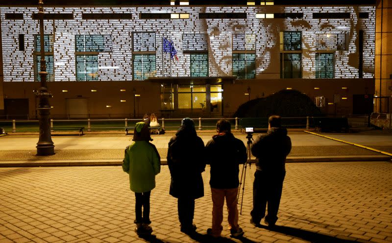 FILE PHOTO: People watch at a light installation called #everynamecounts projecting names of victims of the Nazi regime in Berlin