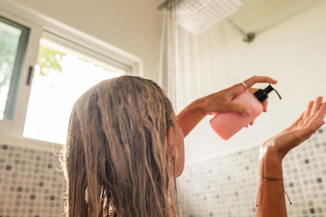 Woman putting soap in her hand in the shower