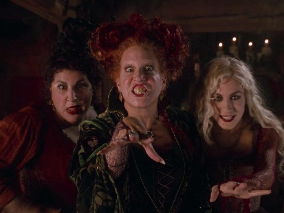 The sanderson sisters lined up in witch outfits in hocus pocus
