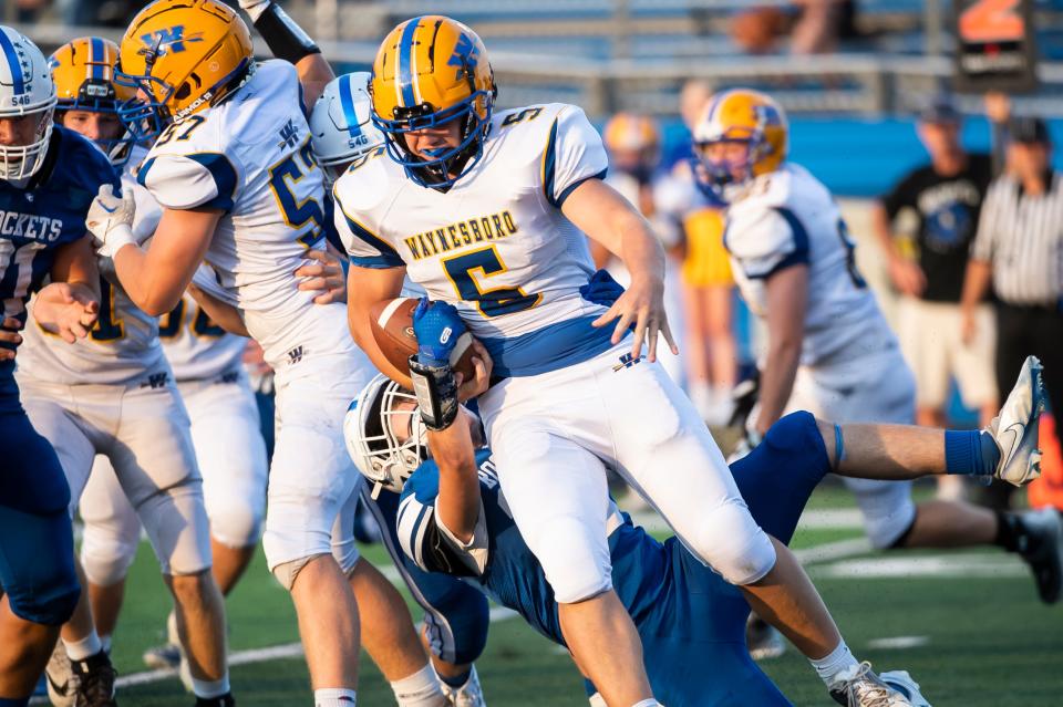 Waynesboro running back Cody Tharp (5) slips a tackle attempt from Spring Grove's Chase Sowers during a non-league matchup on Friday, August 26, 2022, in Jackson Township.