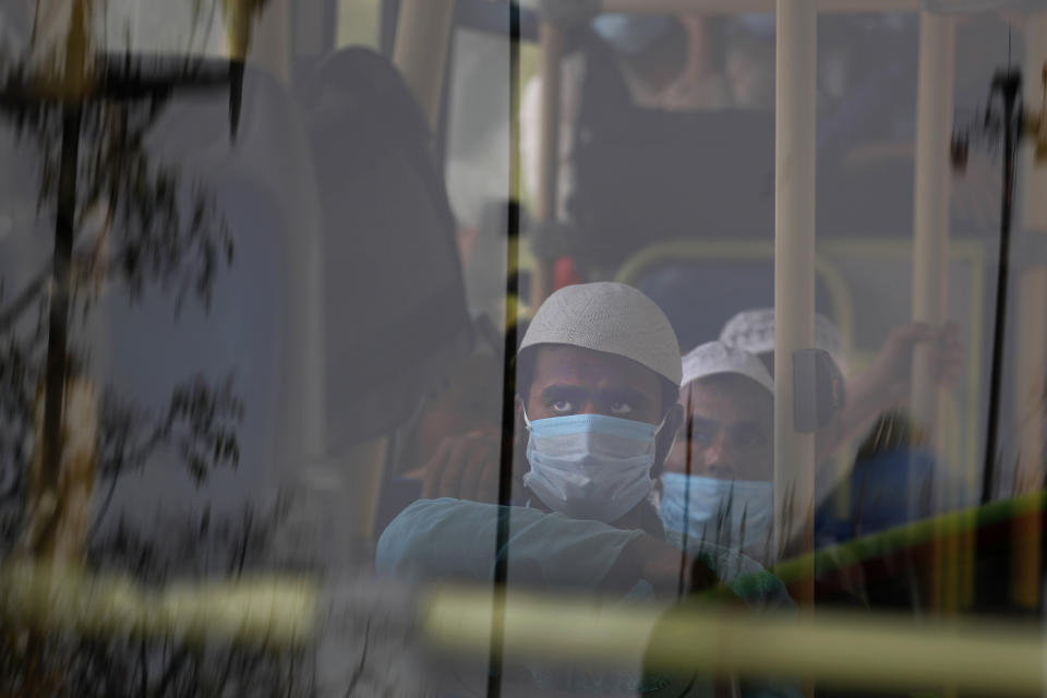 FILE- In this March 31, 2020, file photo, Muslim pilgrims wait in bus that will take them to a quarantine facility, after a government raid discovered the largest viral cluster in India at the Nizamuddin area of New Delhi, India. Muslims in India are being stigmatized after the government blamed an Islamic missionary meeting for a surge in coronavirus cases. Experts who have studied previous epidemics warn that the stigma could hamper efforts to stop the contagion and prevent many from getting themselves tested. (AP Photo/Manish Swarup, File)