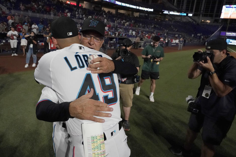 Miami Marlins manager Don Mattingly, rear, hugs starting pitcher Pablo Lopez (49) after a baseball game against the Atlanta Braves, Wednesday, Oct. 5, 2022, in Miami. Mattingly won't be back next season. His contract expires after this season, and both sides agreed it is time for a new voice to lead the club. (AP Photo/Wilfredo Lee)