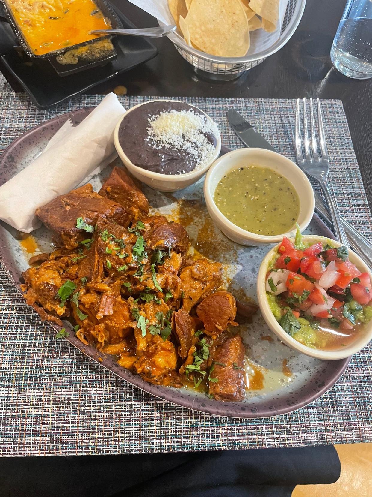 Carnitas entrée served with warm tortillas, guacamole, black beans & salsa borracha at The Battleground Taproom and Mexican Kitchen