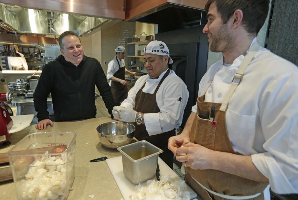 This Feb. 12, 2014, shows chef Paul Kahan, left, speaking to kitchen staff at his restaurant Nico Osteria in Chicago. Kahan is one of the most award-winning chefs in America, but don’t go looking for him on television. In fact, the former computer scientist turned last year's James Beard Award winner for best chef shies away from the spotlight almost entirely. Instead, he chooses to focus on his family and the handful of Chicago restaurants he runs with his partners _ nationally known eateries like Blackbird, avec and The Publican. (AP Photo/M. Spencer Green)