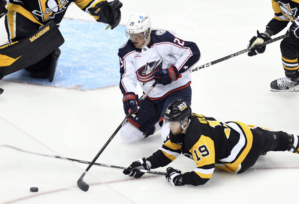 Pittsburgh Penguins forward Liam Foudy (19) blocks a pass from Columbus Blue Jackets left wing Patrik Laine (29) during the first period of an NHL hockey game, Tuesday, March 7, 2023, in Pittsburgh. (AP Photo/Philip G. Pavely)