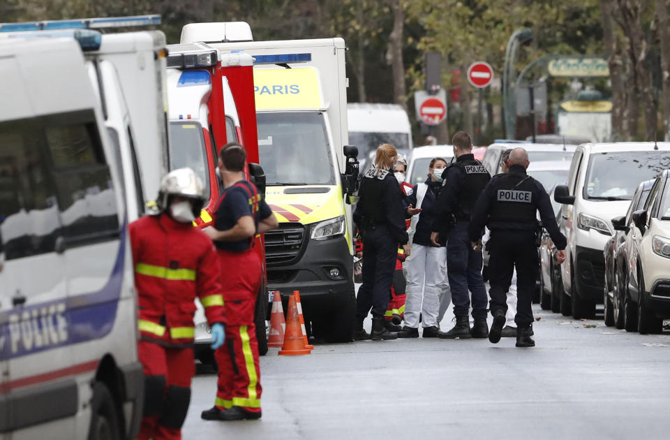 French police officers and rescue workers gather a knife attack near the former offices of satirical newspaper Charlie Hebdo, Friday Sept. 25, 2020 in Paris. A police official said officers are "actively hunting" for the perpetrators and have cordoned off the area including the former Charlie Hebdo offices after a suspect package was noticed nearby. Islamic extremists attacked the offices in 2015, killing 12 people. (AP Photo/Thibault Camus)