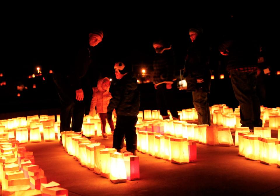 Family members explore the maze set up by San Juan College High School during the college's luminaria display on Dec. 4, 2021 in Farmington.