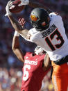 Oklahoma State wide receiver Tyron Johnson (13) makes a catch for a touchdown over Oklahoma cornerback Tre Brown (6) in the first half of an NCAA college football game in Norman, Okla., Saturday, Nov. 10, 2018. (AP Photo/Alonzo Adams)