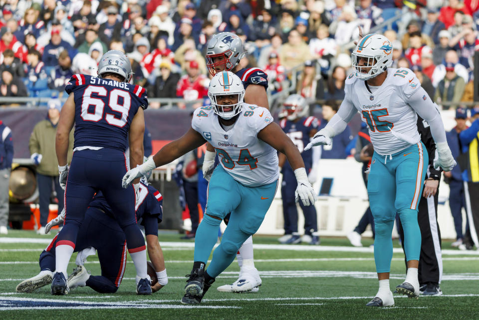 Miami Dolphins defensive tackle Christian Wilkins (94) celebrates with teammate Dolphins linebacker Jaelan Phillips (15) after sacking New England Patriots quarterback Mac Jones (10) during second quarter of an NFL football game, in Foxborough, Mass., Sunday, Jan. 1, 2023. (David Santiago/Miami Herald via AP)