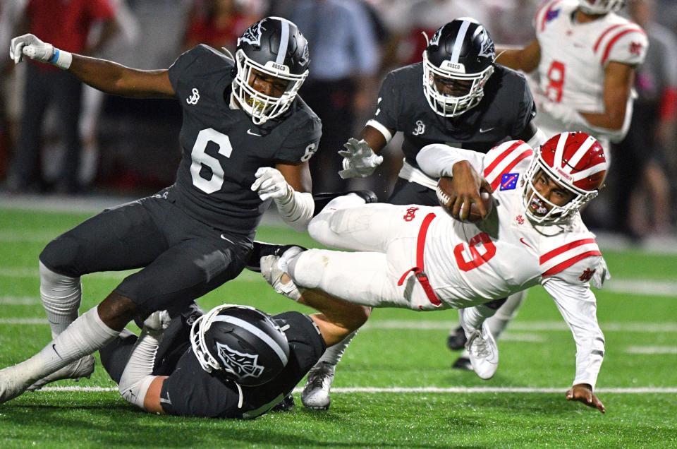 Mater Dei quarterback Bryce Young is tackled during a high school football game against St. John Bosco in Bellflower, Calif.