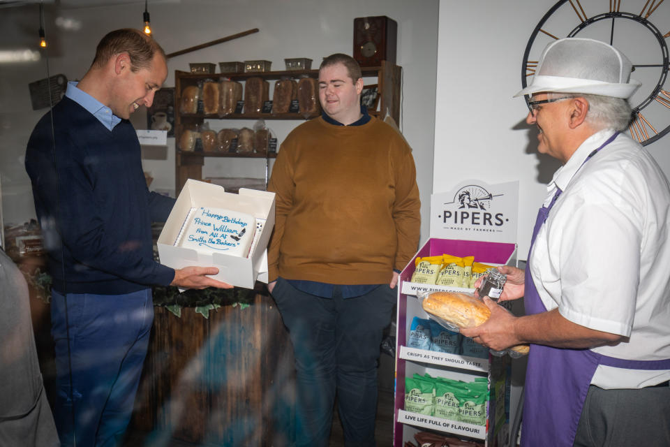 Britain's Prince William, Duke of Cambridge, is presented by shop owner Paul Brandon (R) with a birthday cake, who will be 38 on June 21, during a visit to Smiths the Bakers in the High Street in King's Lynn, eastern England on on June 19, 2020. - The Duke visited the independent business to hear about the impact of the Covid-19 pandemic. (Photo by Aaron Chown / POOL / AFP) (Photo by AARON CHOWN/POOL/AFP via Getty Images)