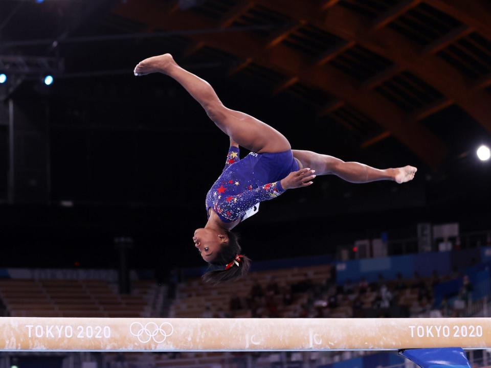 Simone Biles flips on the balance beam.