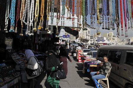 Shoppers stroll along a street at a main commercial trading area in downtown Amman in this January 21, 2014 file photo. REUTERS/Muhammmad Hamed/Files