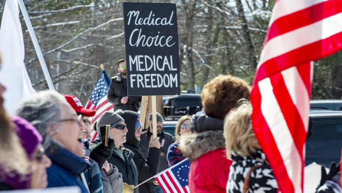 A protester among attendees at the kickoff rally for a protest convoy holds a sign reading: Medical choice medical freedom.
