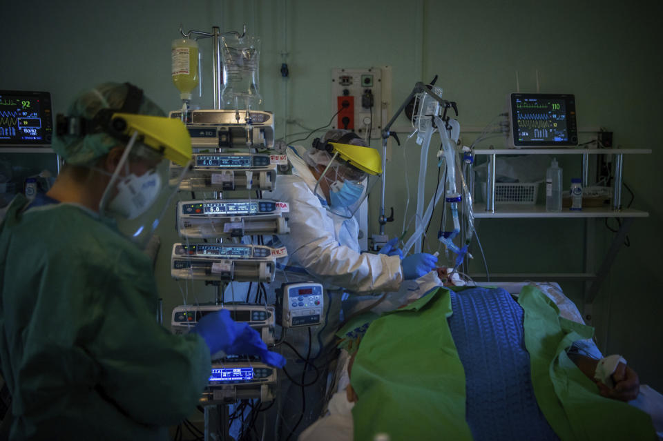 A doctor examines a patient in the intensive care unit for COVID-19 patients in the Szent Laszlo hospital in Budapest, Hungary, on April 22, 2020. (Zoltan Balogh / MTI via AP file)