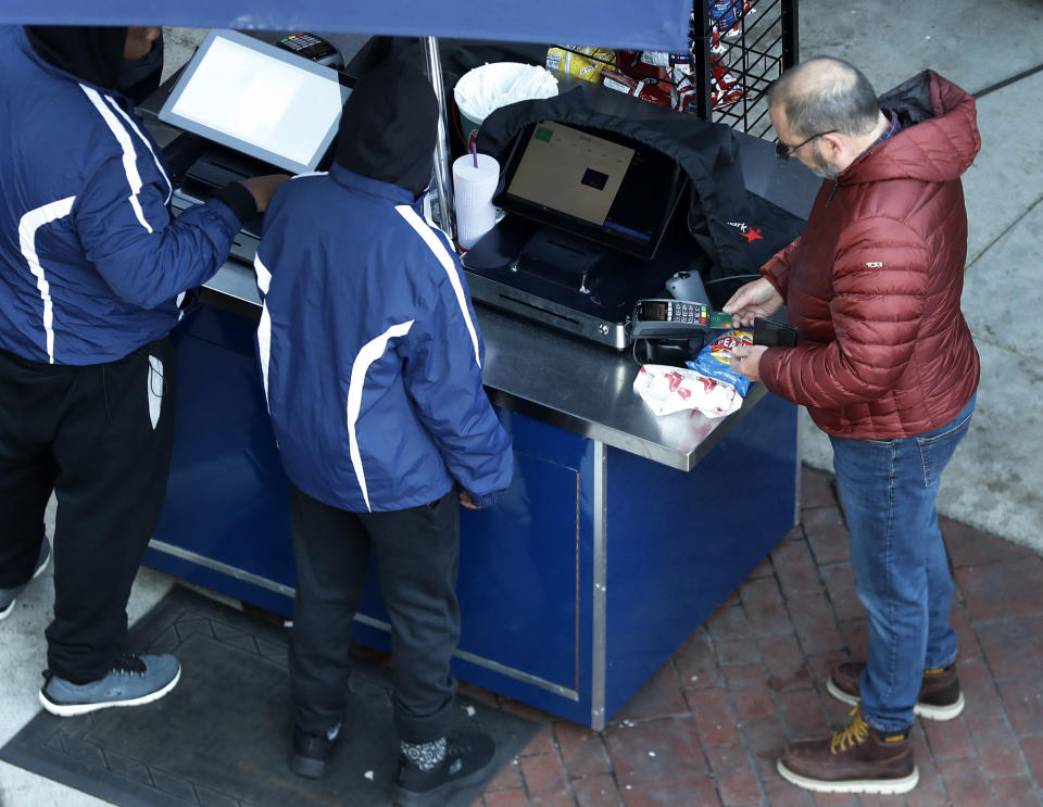 The Boston Red Sox have made transactions at Fenway Park cashless this season. A fan is pictured about to use his credit card at a concession stand. (Credit: Jim Davis, Globe Staff).