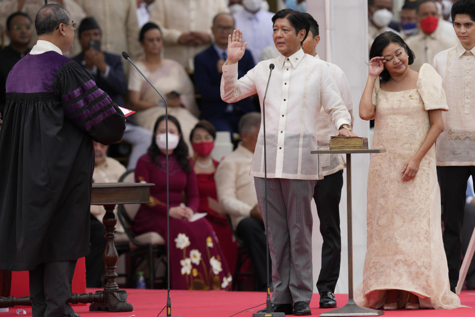 FILE - President-elect Ferdinand "Bongbong" Marcos Jr., center, is sworn in by Supreme Court Chief Justice Alexander Gesmundo, left, while his wife Maria Louise Marcos, right, reacts during the inauguration ceremony on June 30, 2022 in Manila, Philippines. Marcos Jr. has reaffirmed ties with the United States, the first major power he visited since taking office in June, in a key turnaround from the often-hostile demeanor his predecessor displayed toward Manila's treaty ally. (AP Photo/Aaron Favila, File)