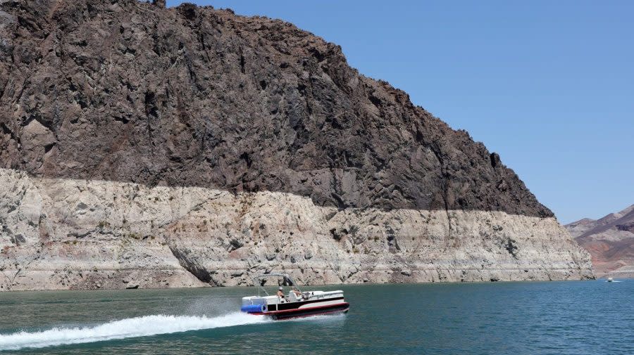 <em>Boaters cruise in front of mineral-stained rocks in The Narrows upstream of the Hoover Dam on July 28, 2022, in the Lake Mead National Recreation Area, Nevada. The week prior, Lake Mead dropped to just 27 percent of its capacity, with the water level at its lowest since being filled in 1937 after the construction of the Hoover Dam as a result of a climate change-fueled megadrought coupled with increased water demands in the Southwestern United States. The drought has left a white “bathtub ring” of mineral deposits left by higher water levels on the rocks around the lake. (Photo by Ethan Miller/Getty Images)</em>