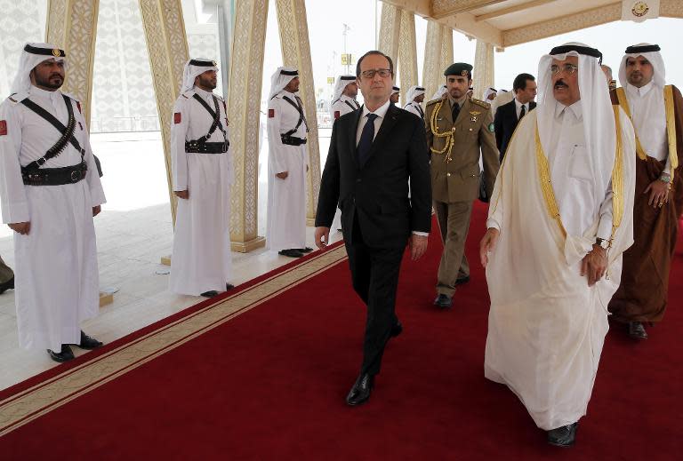 Francois Hollande (centre) is greeted by Qatar's Culture Minister Hamad Bin Abdulaziz Al-Kuwari at Doha airport, on May 4, 2015