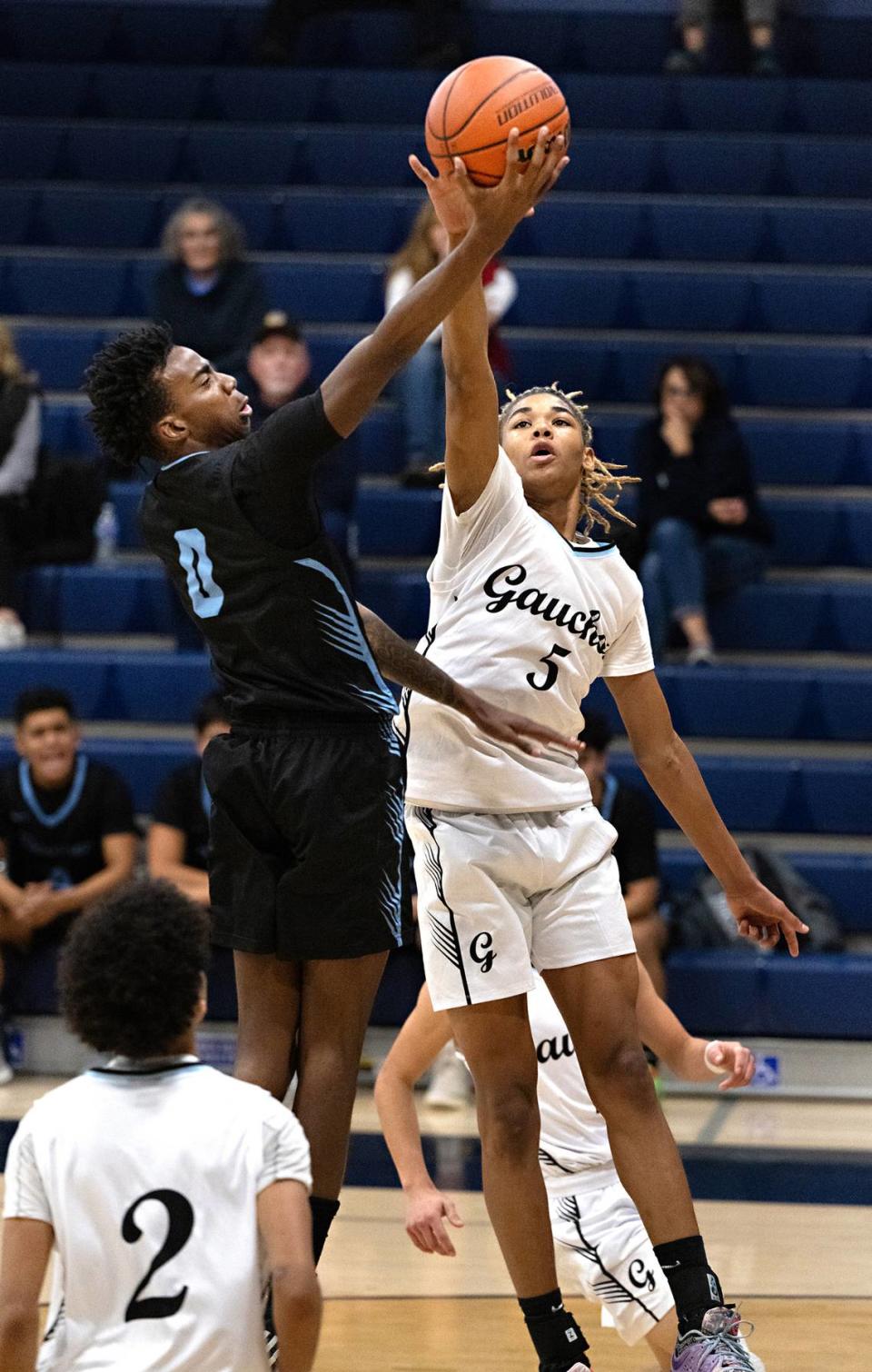 Downey’s Reuben Lewis drives to the basket as El Capitan’s Anthony Jones defends during the Mark Gallo Invitational Basketball Tournament at Central Catholic High School in Modesto, Calif., Friday, Dec. 8, 2023. El Capitain won the game 54-44.