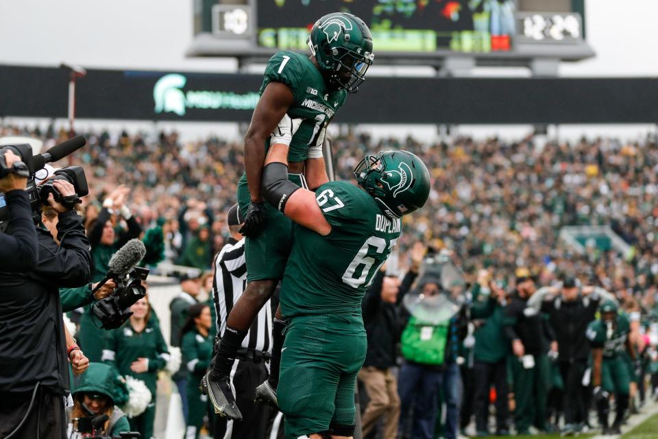 Michigan State wide receiver Jayden Reed is lifted by offensive lineman J.D. Duplain after scoring a tying two-point conversion against Michigan during the fourth quarter at Spartan Stadium in East Lansing on Saturday, Oct. 30, 2021.