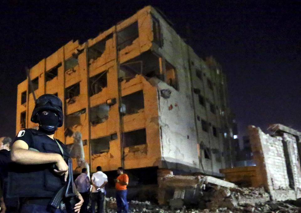 A security official stands guard at the site of a bomb blast at a national security building in Shubra Al-Khaima, on the outskirts of Cairo