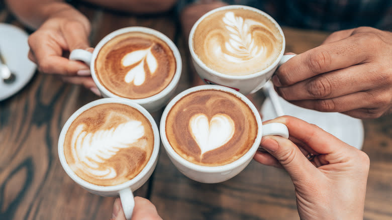 Friends holding crafted espresso beverages