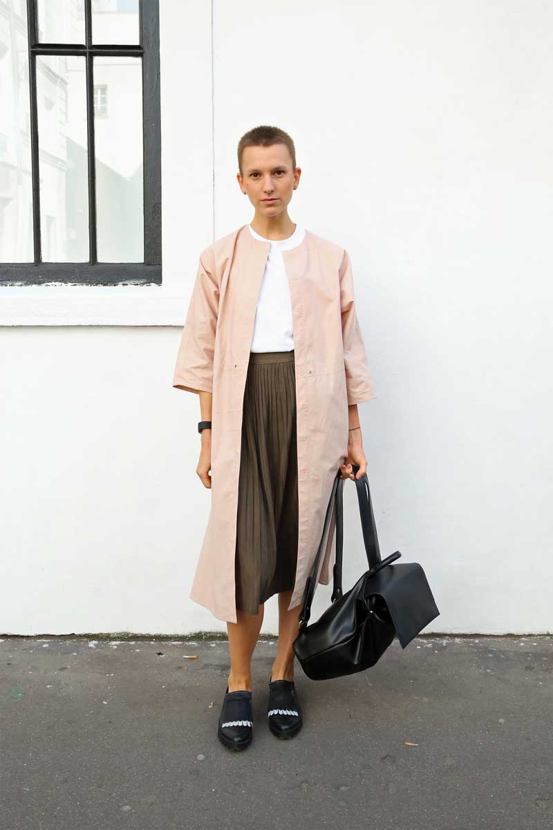 <p>Die Fashionista liegt mit ihrer Mantelfarbe voll im Trend des kommenden Frühjahrs: Rosa in allen Nuancen. Dazu ein Plisseerock, ein trendiger Rucksack und bequeme Flats. Genau das richtige Outfit für einen langen Tag bei der Paris Fashion Week. (Bild: Getty Images)</p>