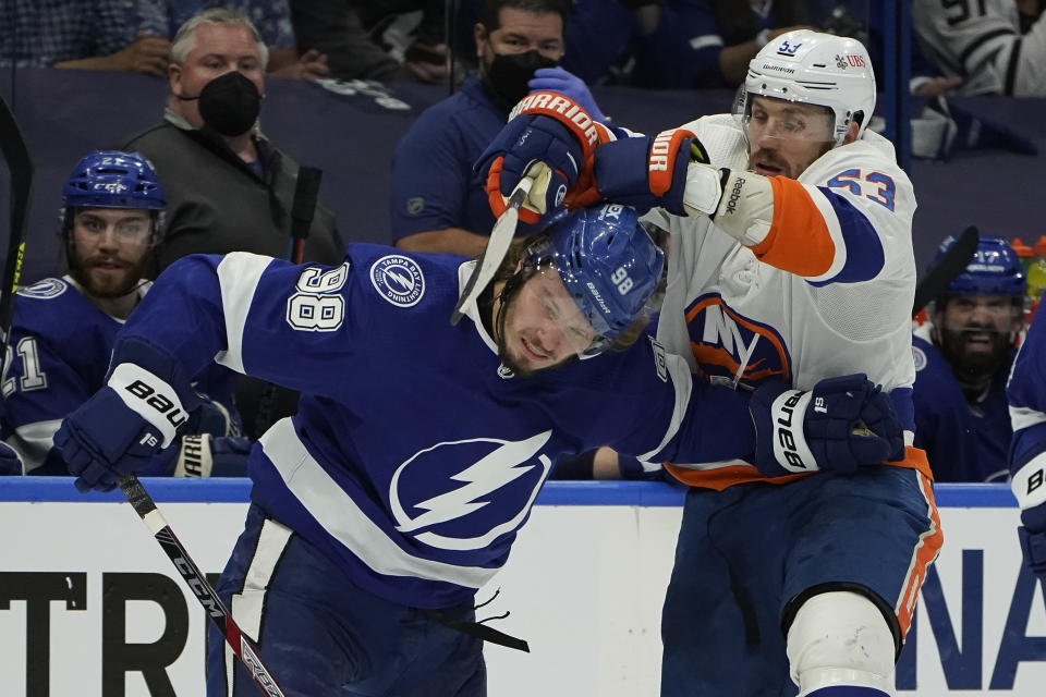 Tampa Bay Lightning defenseman Mikhail Sergachev (98) and New York Islanders center Casey Cizikas (53) collide during the first period in Game 5 of an NHL hockey Stanley Cup semifinal playoff series Monday, June 21, 2021, in Tampa, Fla. (AP Photo/Chris O'Meara)