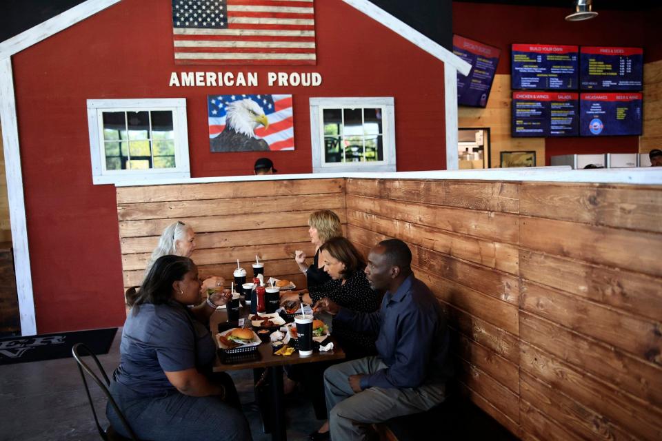 Angie Graves (left) talks with Vladimir Olivier (right) as they sit down to lunch at the new Burger Barn Grill, 9303 Baymeadows Road in Jacksonville.