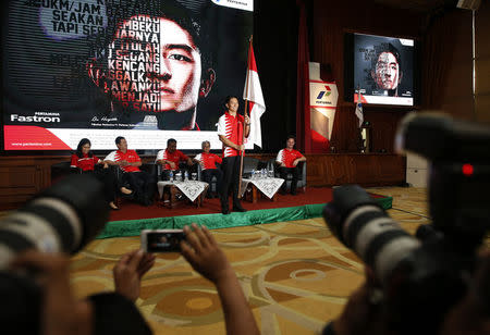 Rio Haryanto, Indonesia's first Formula One driver, holds an Indonesian flag at an event announcing his signing with Manor Racing at Pertamina headquarters in Jakarta, Indonesia February 18, 2016. The 23-year-old Haryanto will make his race debut in Australia when the season starts on March 20. REUTERS/Darren Whiteside