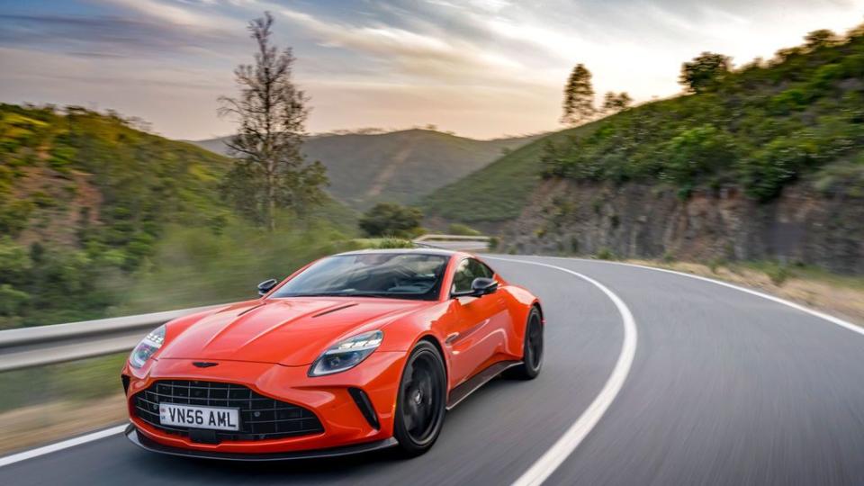 a red 2025 aston martin vantager driving on a road