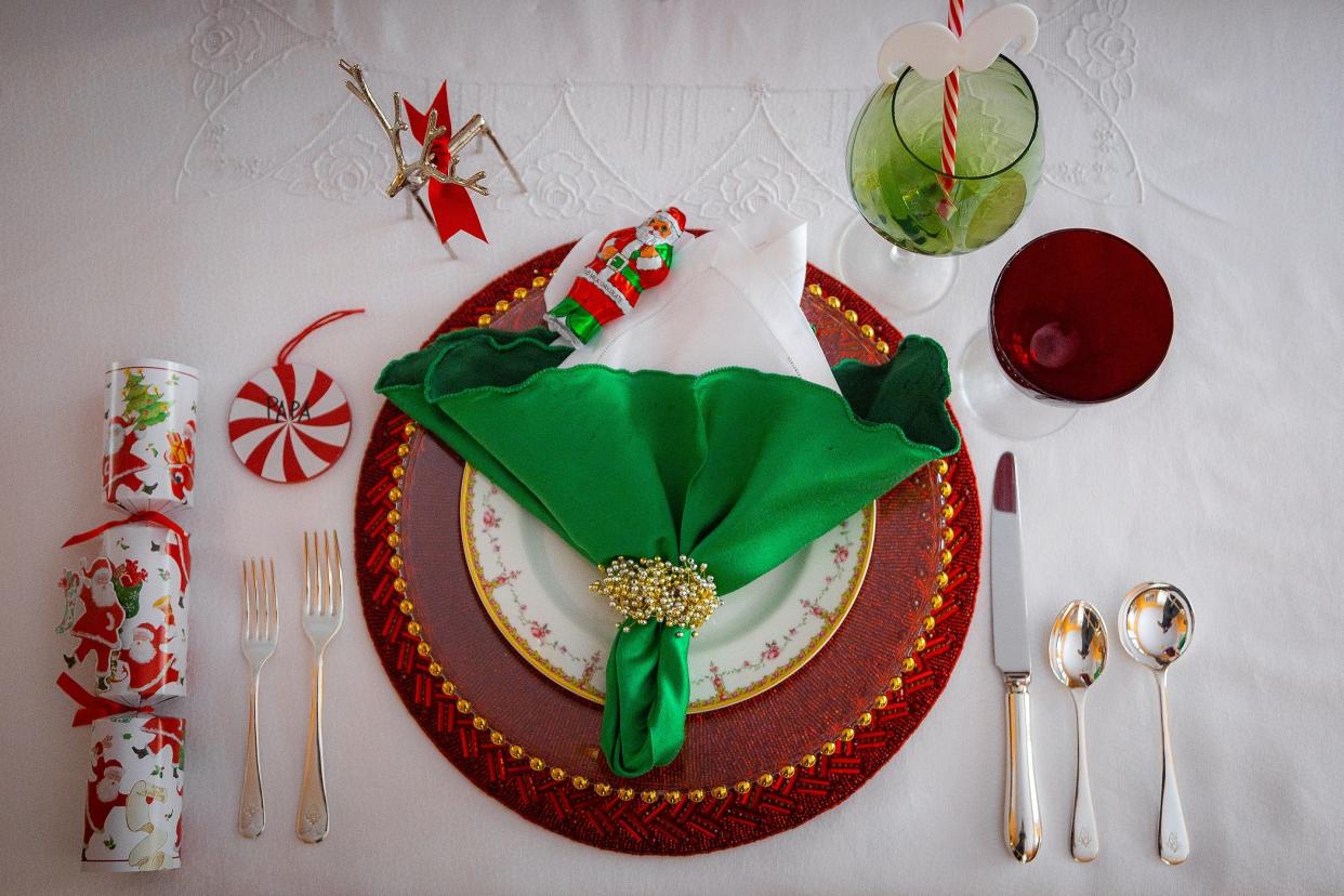 Penny Murphy's table setting celebrates the reds and greens of the season, from peppermint name card, to charger, plate and napkin.